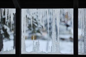 A window with icicles hanging from it's side.