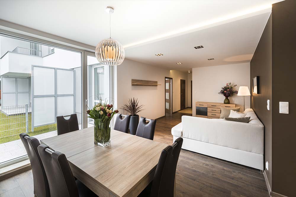 A dining room table and chairs in front of a living room.