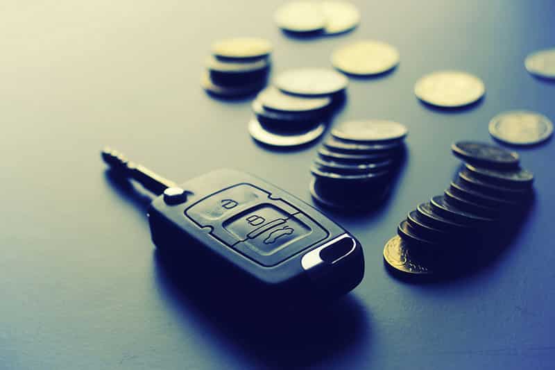 A car key sitting on top of some coins.