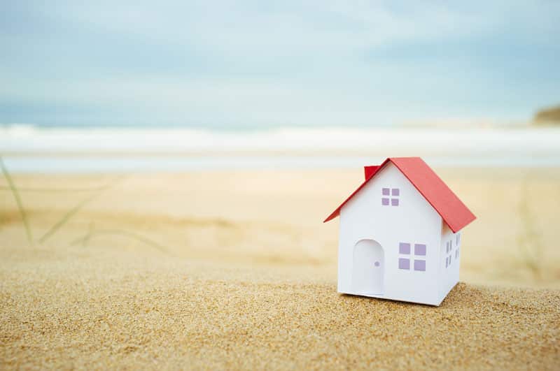 A small white house sitting on top of the beach.