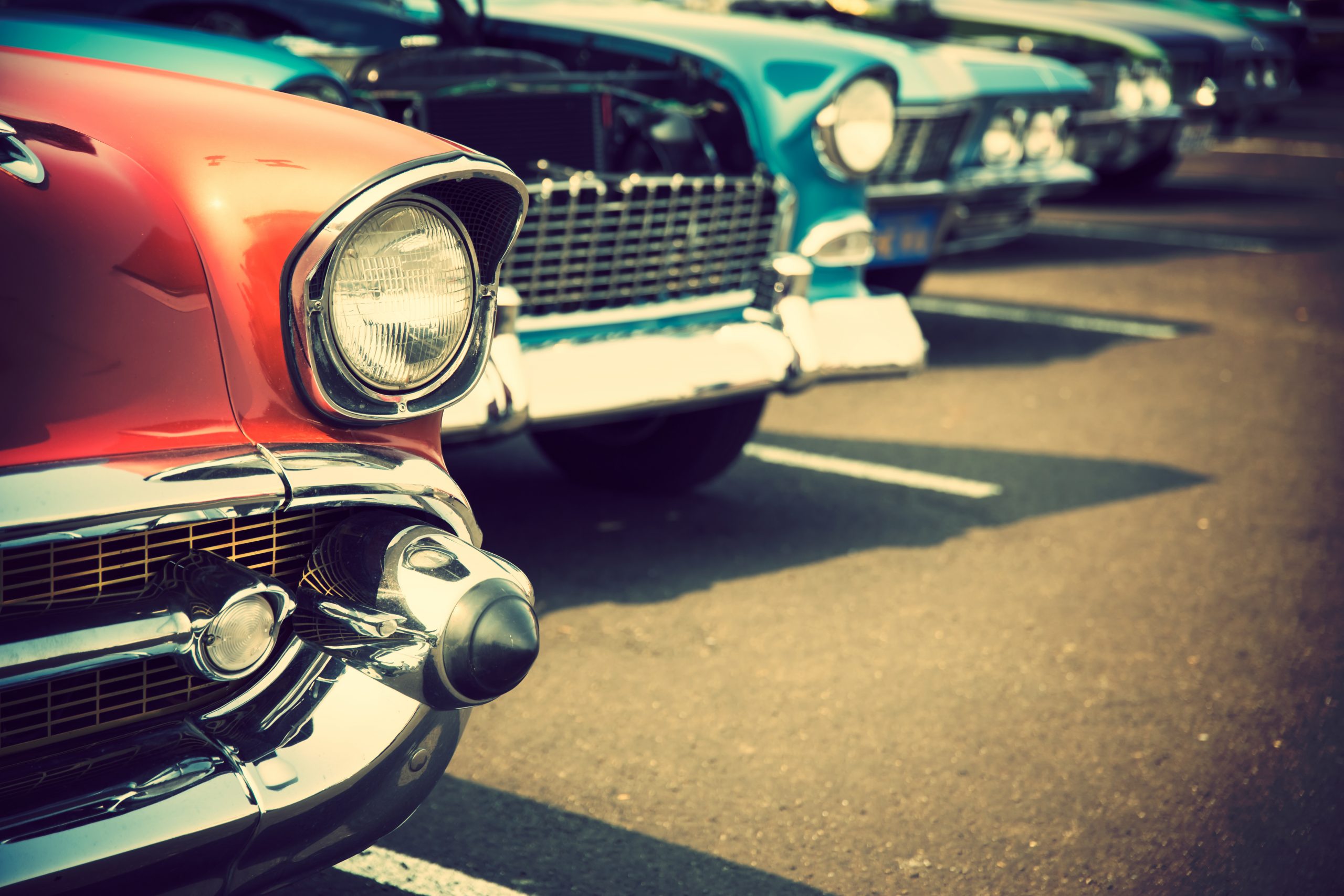 A row of old cars parked in the street.