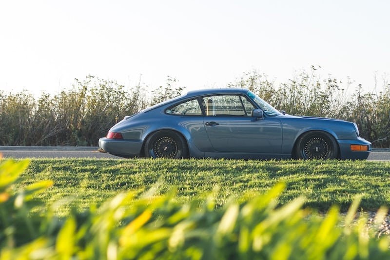 A blue car is parked in the grass