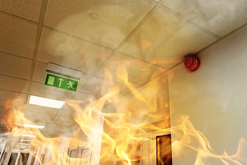 A fire is burning in the ceiling of an office building.