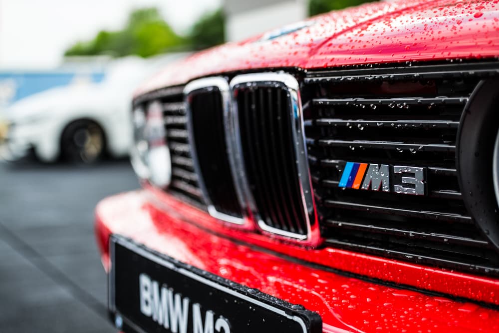 A close up of the front grill on a red bmw m 3.