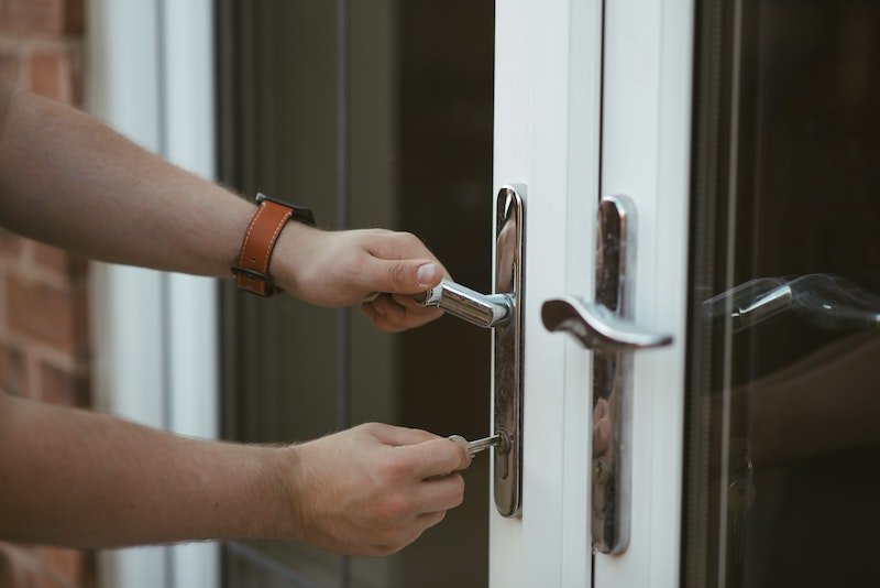 A person is holding on to the handle of a door.