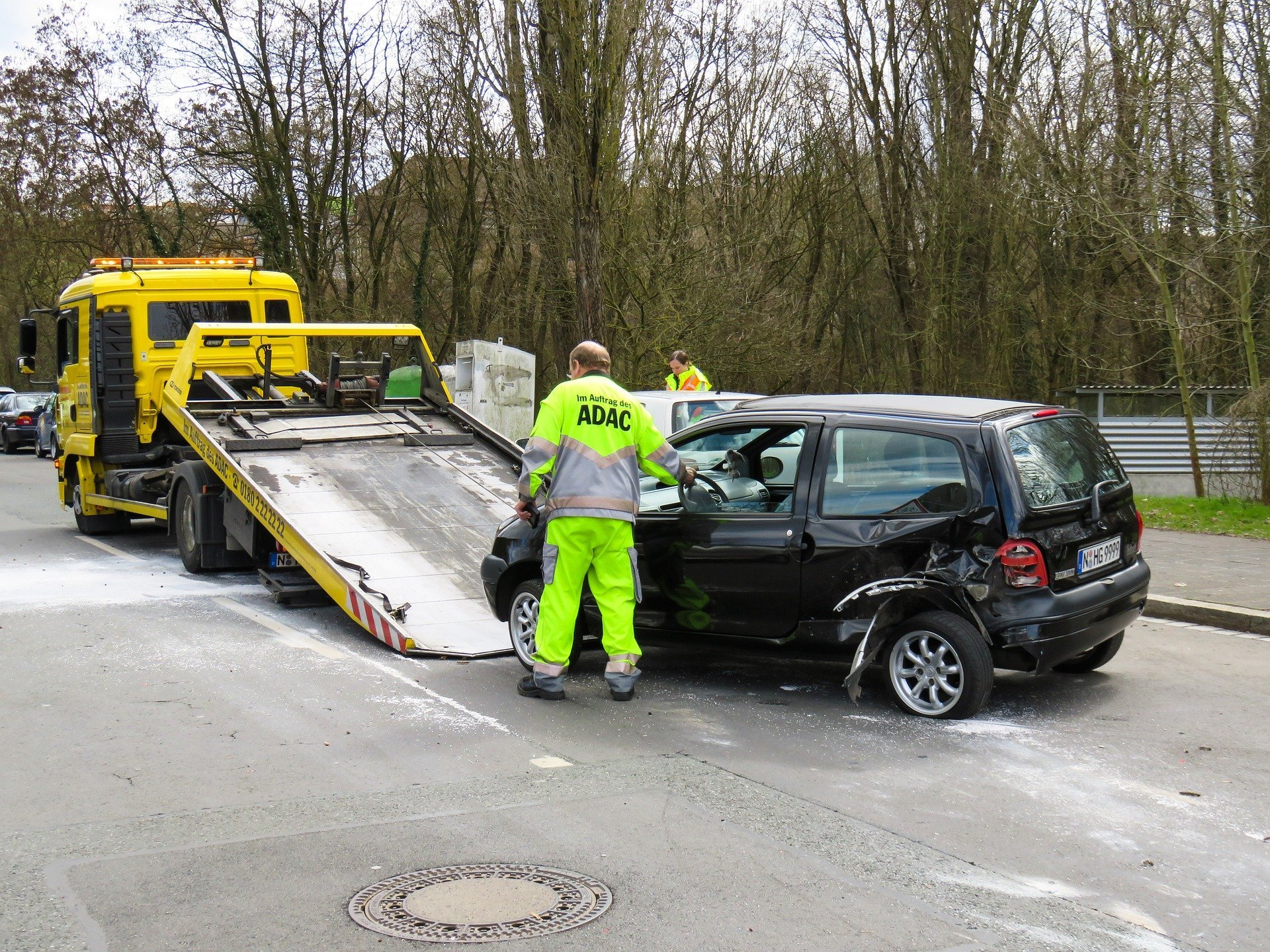 A tow truck is towing a car that has been pulled over.