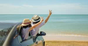 Two people in a car on the beach