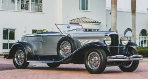 A vintage car parked on the side of a road.