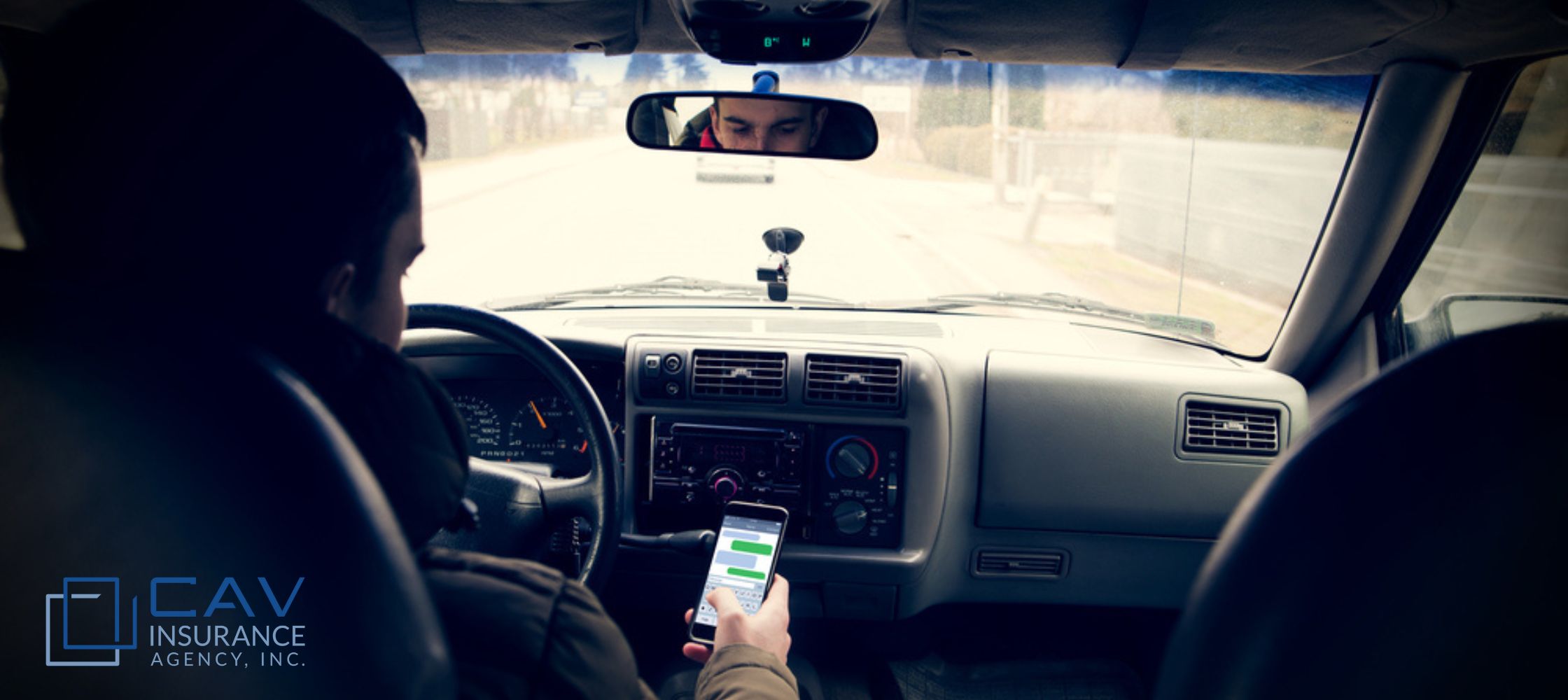 A person is holding their phone while driving.