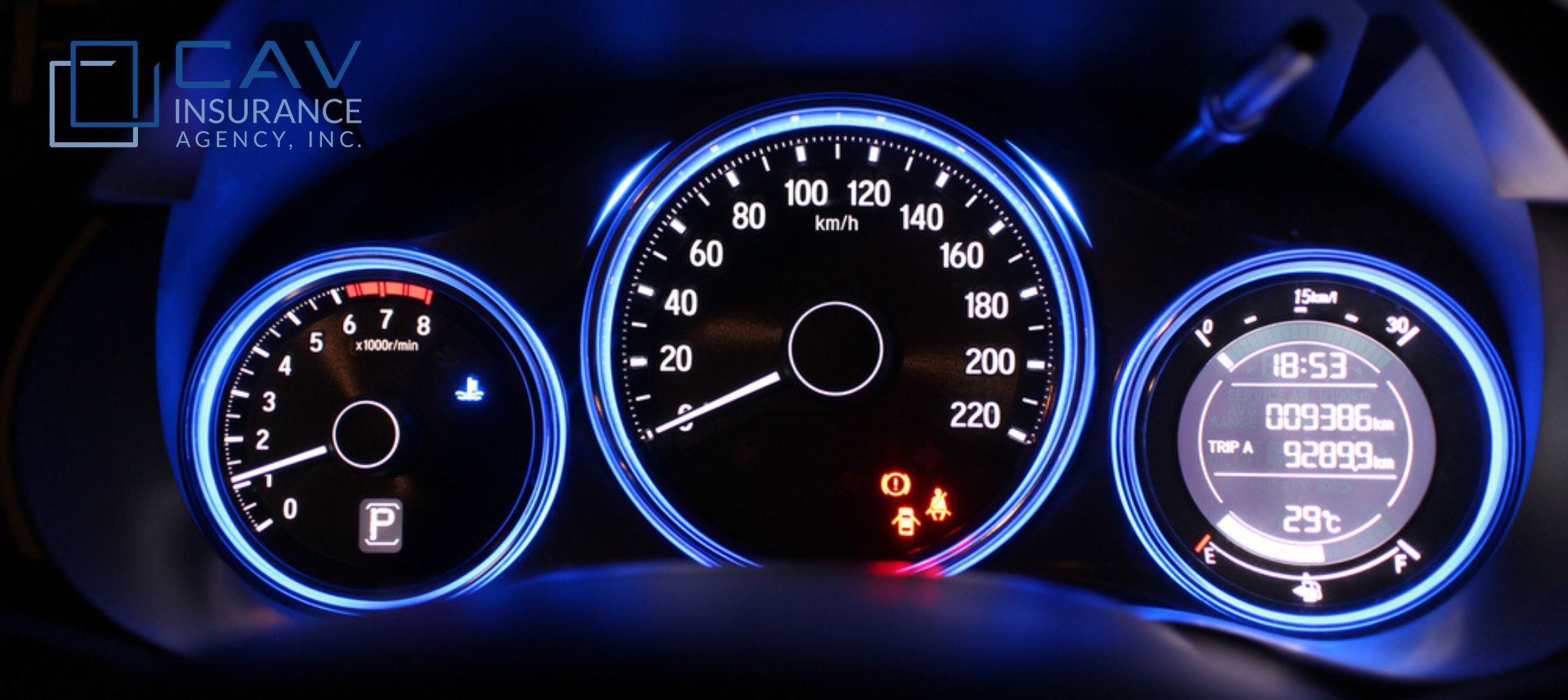 A car dashboard with the lights on and blue light.